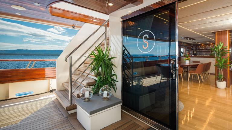 A noble glass door with the Son de Mar emblem separates the indoor and outdoor areas.